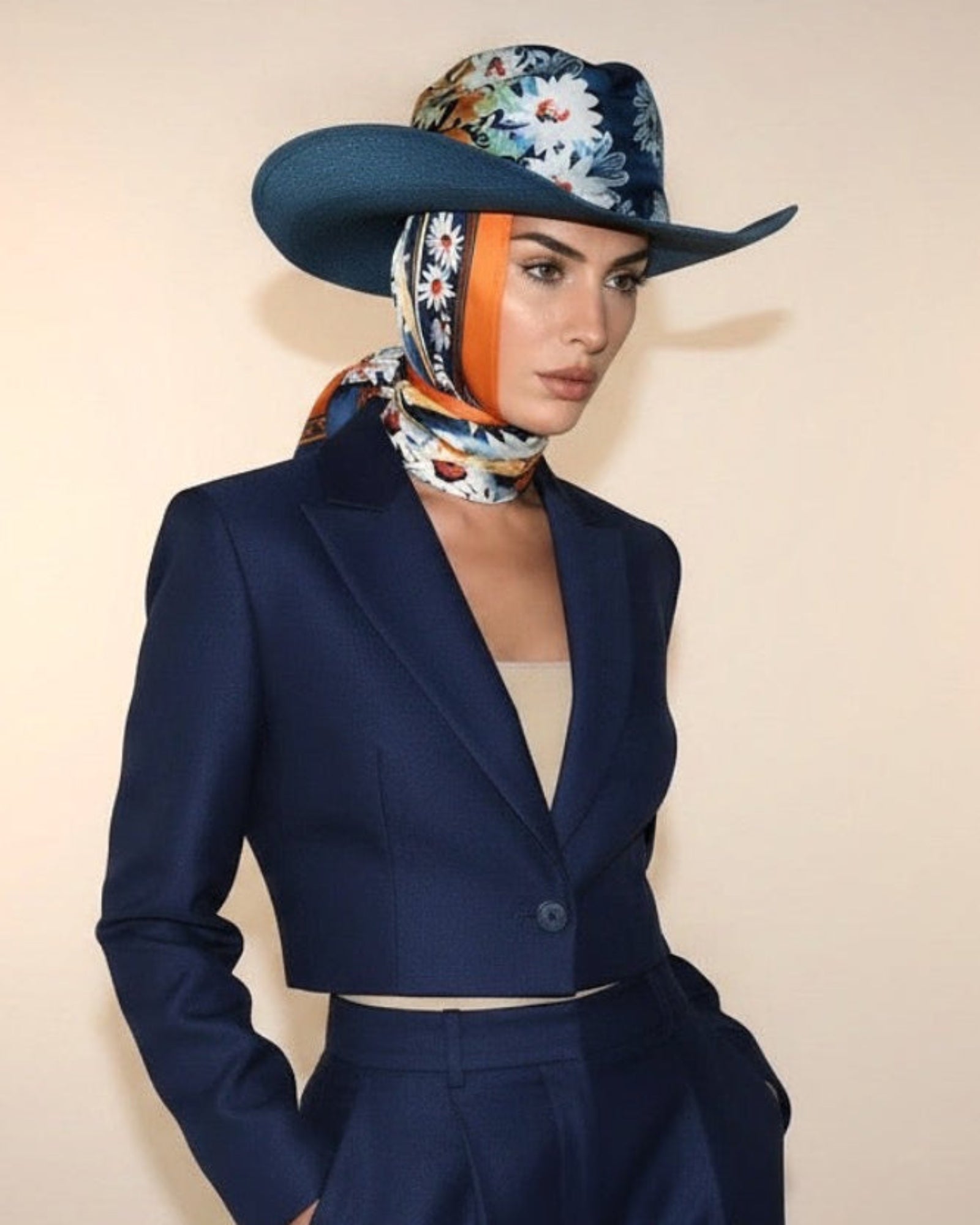 Model wearing the Mykonos Charm straw hat with silk scarf, featuring a relaxed silhouette with refined coastal style.